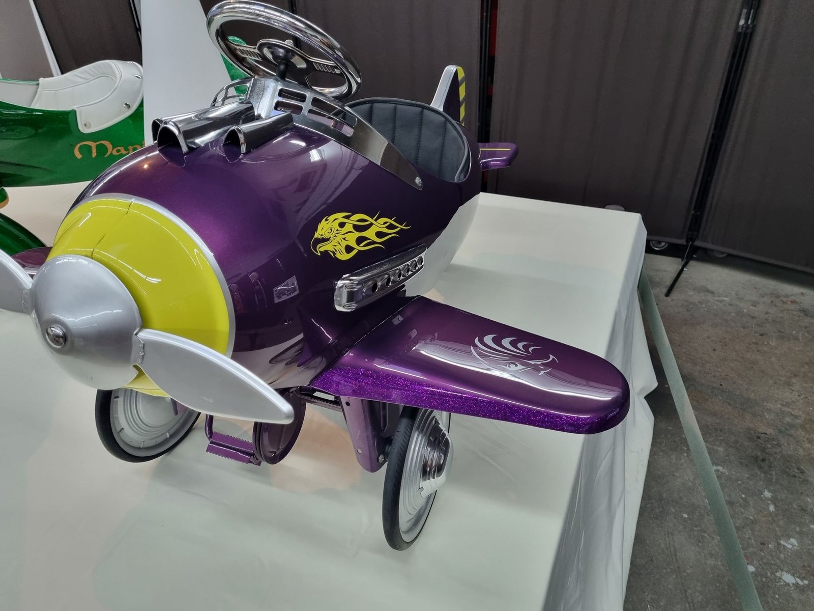 Ein lila Flugzeug mit einem gelben Propeller steht auf einem Tisch